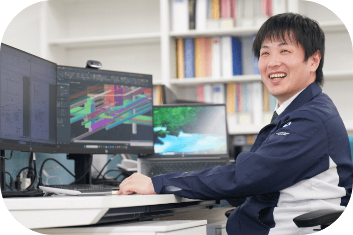 CAD画面の前で笑顔を見せるM.Wさん